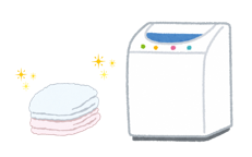 畳まれた洗濯物と洗濯機の画像