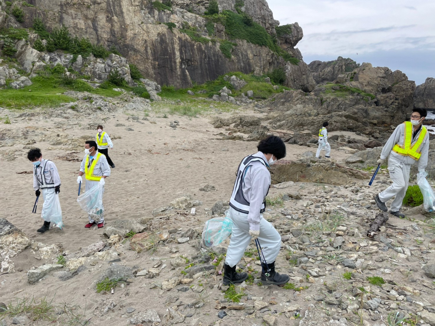 砂地や岩場でごみをひろう方たち