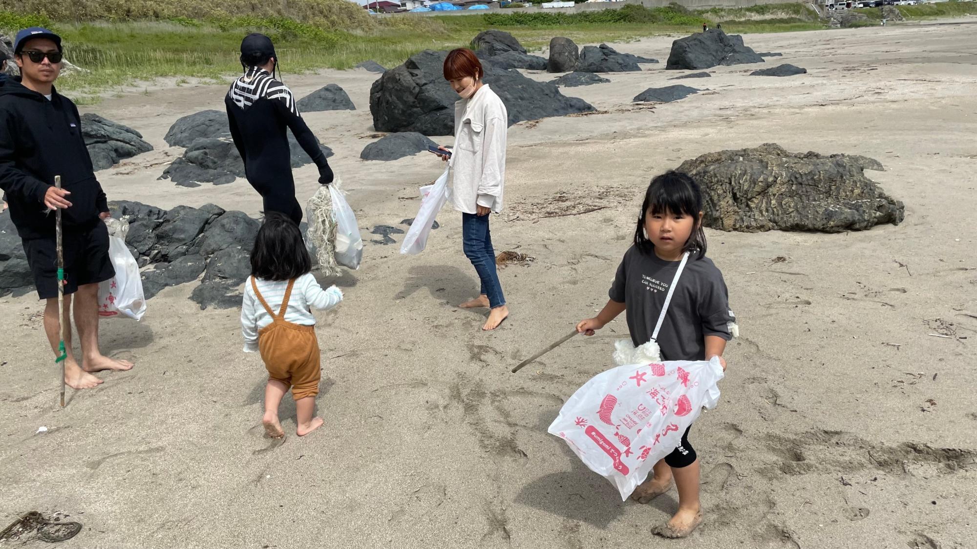 子どもたちもごみ袋とトングを手に活動している写真
