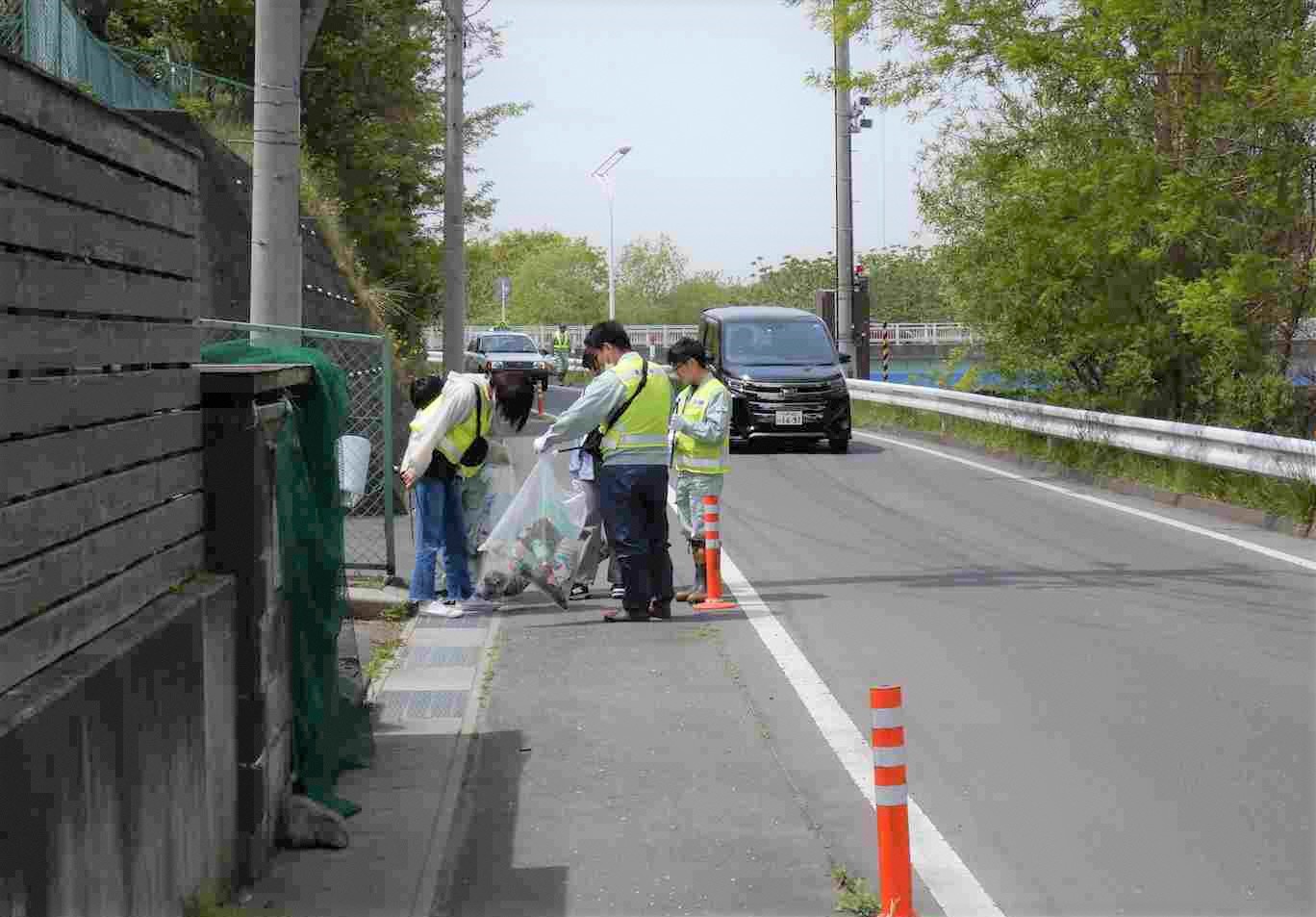 住宅地の道路脇のごみを拾っている写真