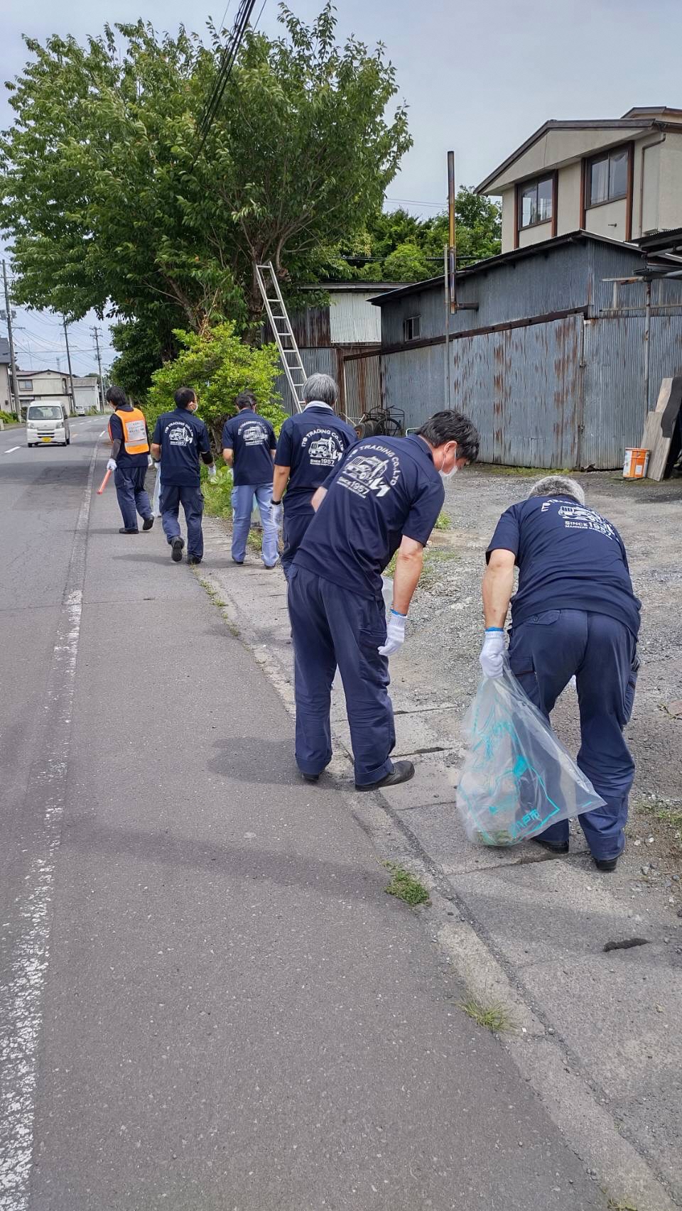 道路端のごみを拾う男性6人