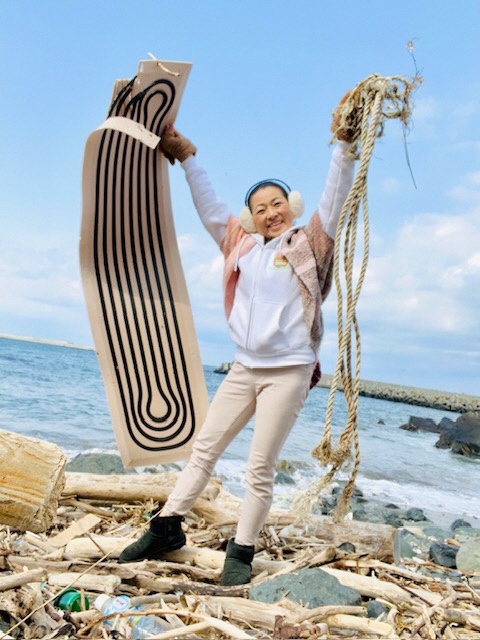 拾った縄などを掲げている女性の写真