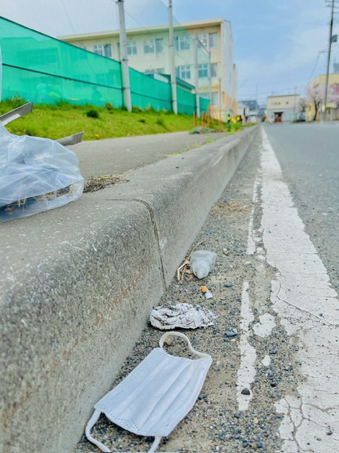道路に捨てられたマスクの写真