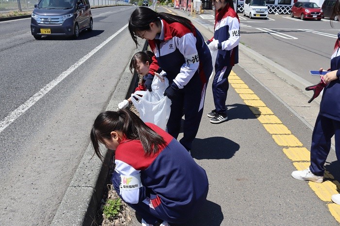 歩道のごみを拾っている生徒たちの写真