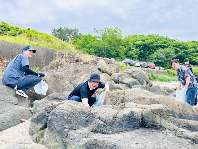 大きな岩の間のごみを拾っている写真