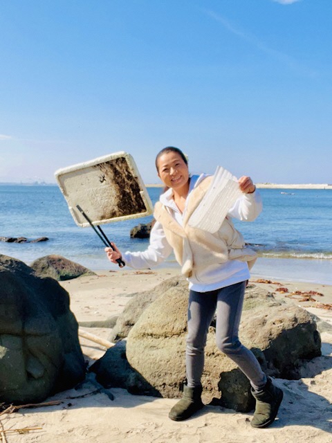 拾った発泡スチロールを見せている女性の写真