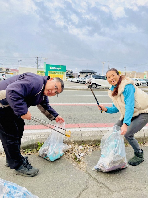 夫婦で歩道のごみを拾っている様子