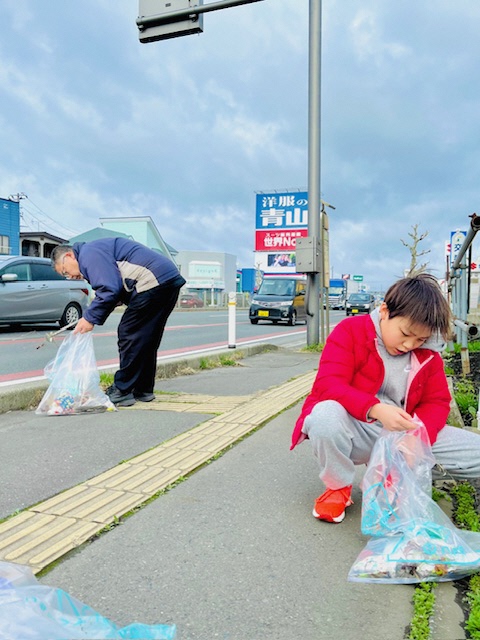 親子で歩道のごみを拾う様子