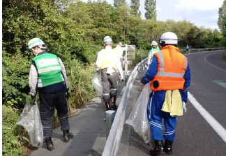 安全確認をしながら歩道のごみを拾っている様子