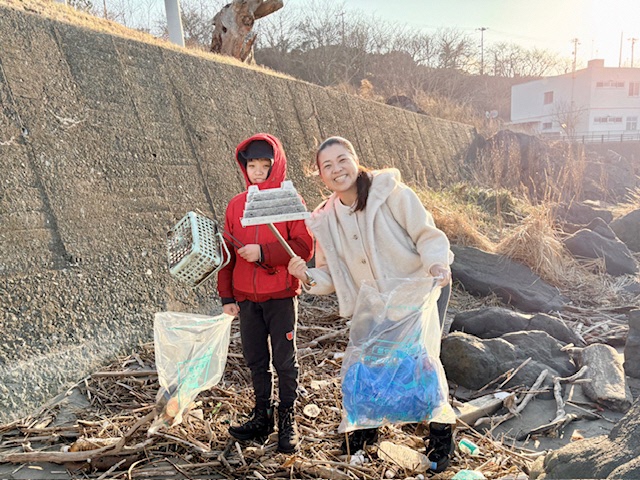 親子で海岸のごみを拾う写真 1