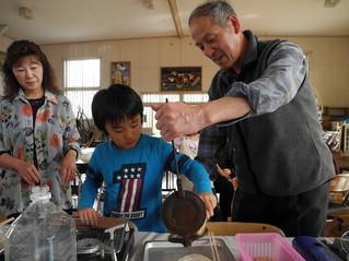 てんぽせんべい焼きの指導を受ける子供たちの写真