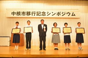 賞状を持った5人の生徒がステージに立っている写真