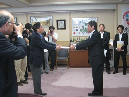 青森県庁で三村知事に要請書を手渡す小林市長の写真