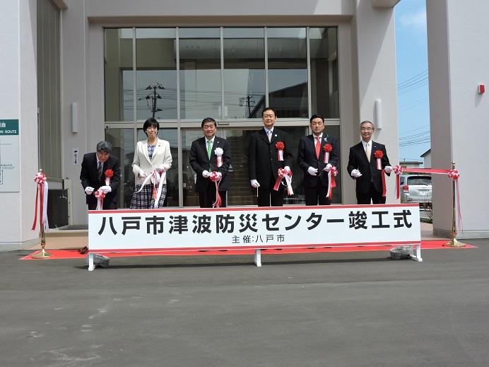 八戸市津波防災センター竣工式で5名の関係者と市長がテープカットをしている写真