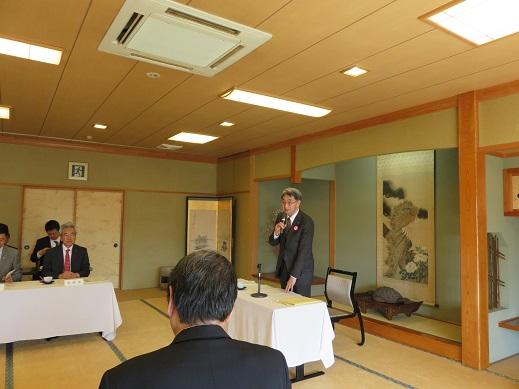「富士見館」の和室で行われた青森県市長会総会会場内で男性が立ちマイクを右手に持って話しをしている写真