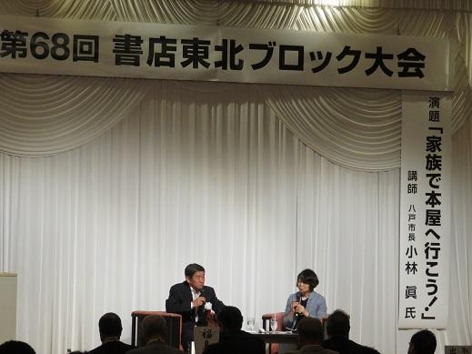 舞台に座り、青山 友子さんと対談している市長の写真
