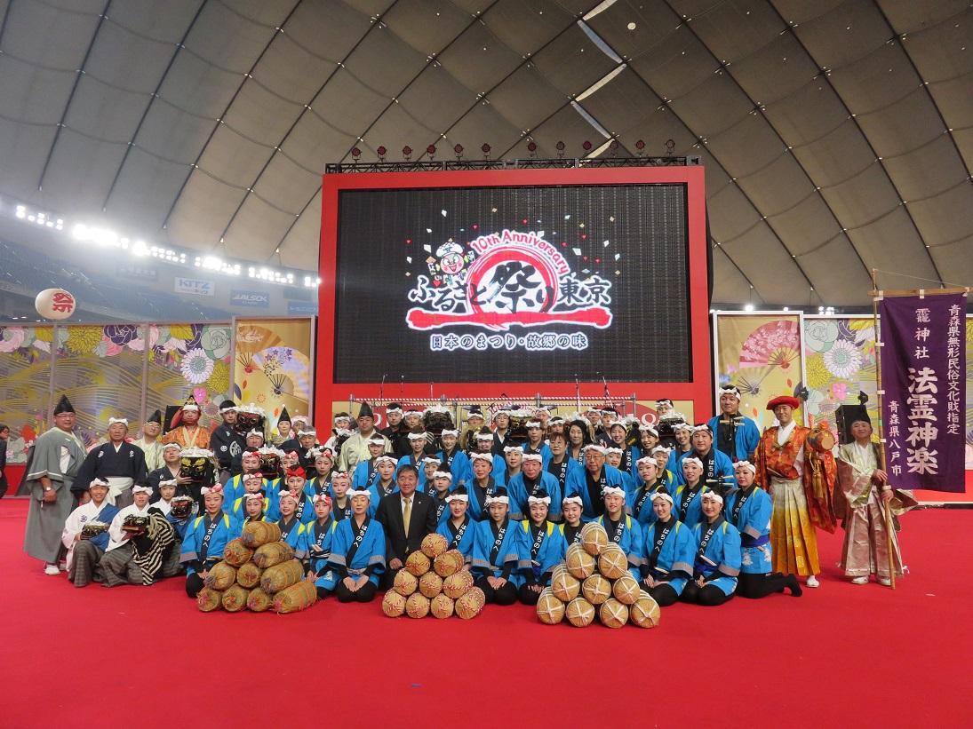 水色の法被を着た人たちや神楽の装いに扮したふるさと祭り東京2018出演の方々との集合記念写真