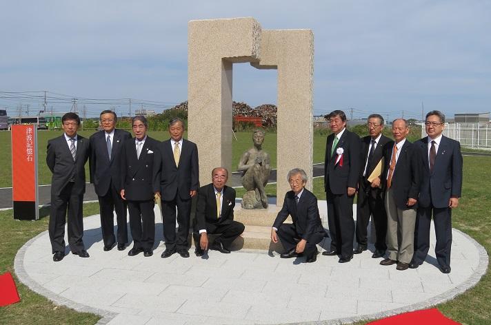 津波記憶石除幕式で石憎の前で関係者の皆様と記念撮影をしている市長の写真