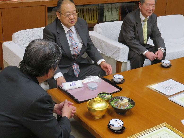 「八戸銀サバトロづけ丼」が市長の前に並べられ、沢上 弘駅長と対談している写真