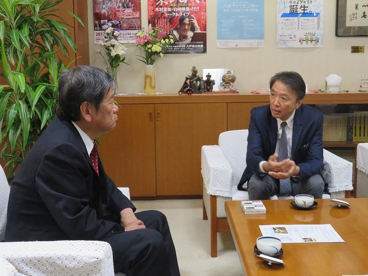 市長室の白い椅子に座り工藤浩成（ひろまさ）様と会談している市長の写真
