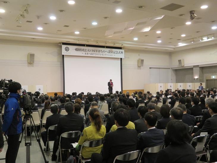 VISIT八戸設立記念式典で大勢の出席者が席につきその前で挨拶をしている市長の写真