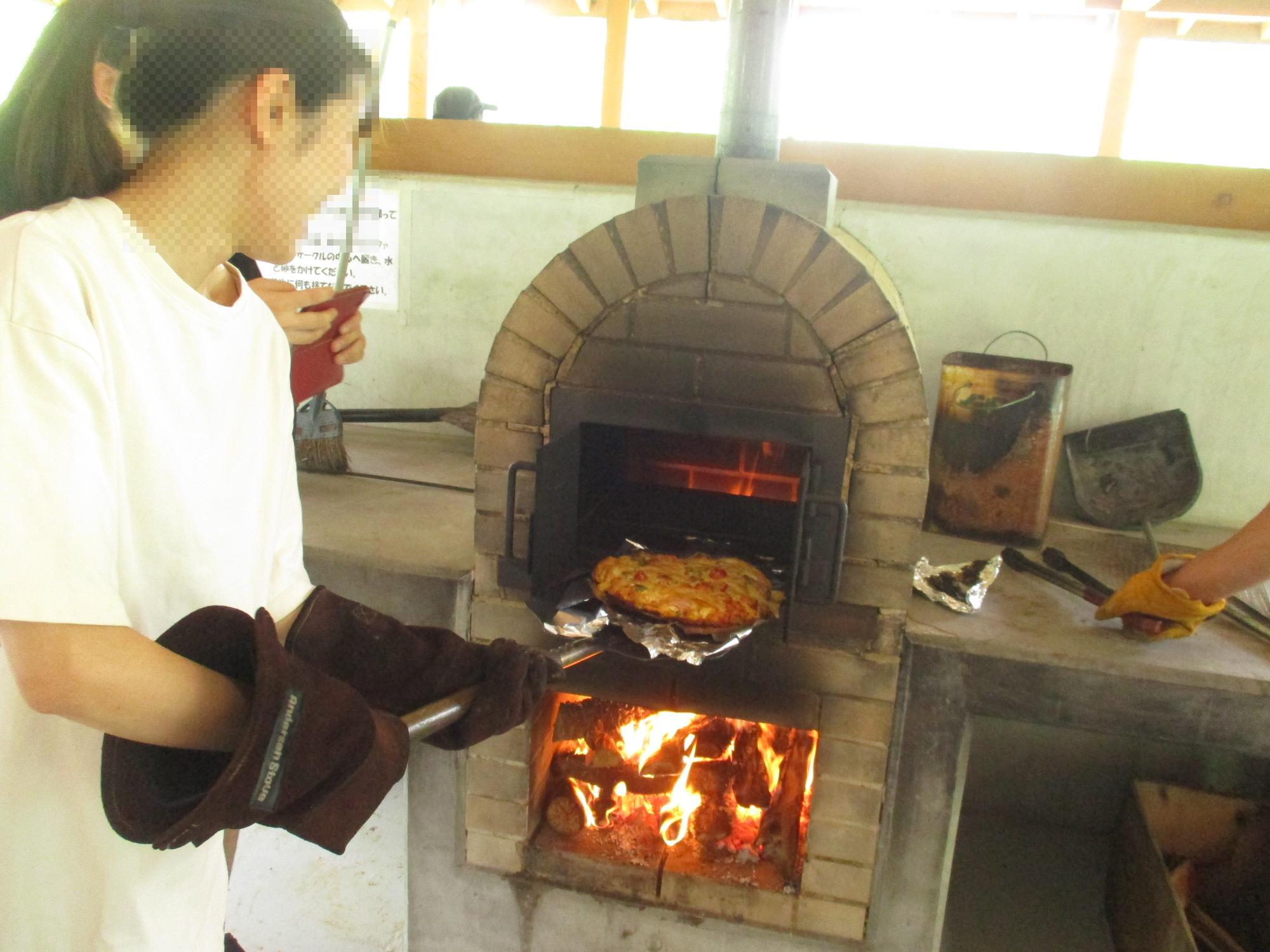 ピザ焼き体験をしている女性