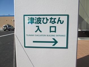 英文と矢印を併記した「津波ひなん入口」の案内板の写真
