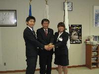 JICA青年海外協力隊員の澤野慶太さんと石藤可苗さんが小林眞市長と手を合わせ記念撮影している写真