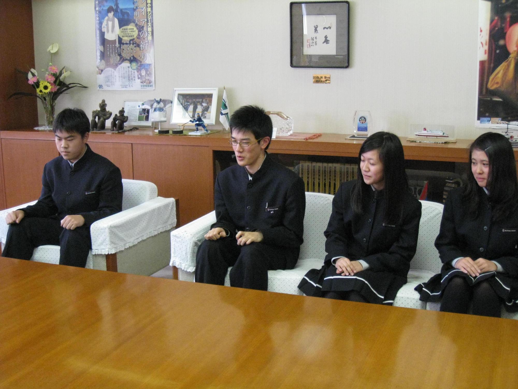 八戸聖ウルスラ学院高等学校の代表生徒4名が、小林市長に表敬訪問し、会話している写真