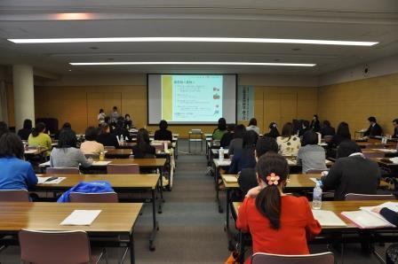 八戸市庁別館2階会議室B・Cでスクリーンを使って説明する講師と説明を聞く大勢の女性受講者達の写真