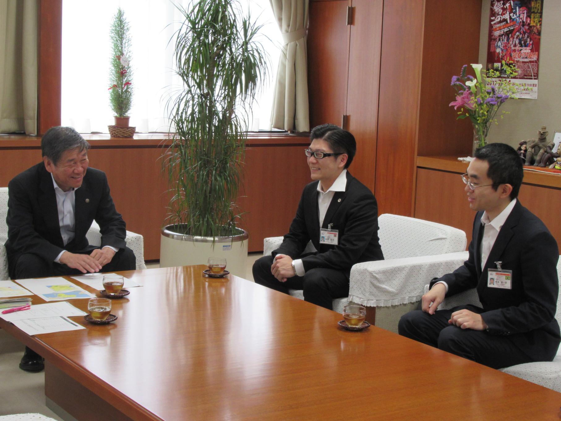 JICA青年海外協力隊員と小林市長が白いソファーに座って、話している写真