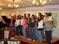 歓迎会で歌を披露しているグランドヌメア高校生徒達の写真