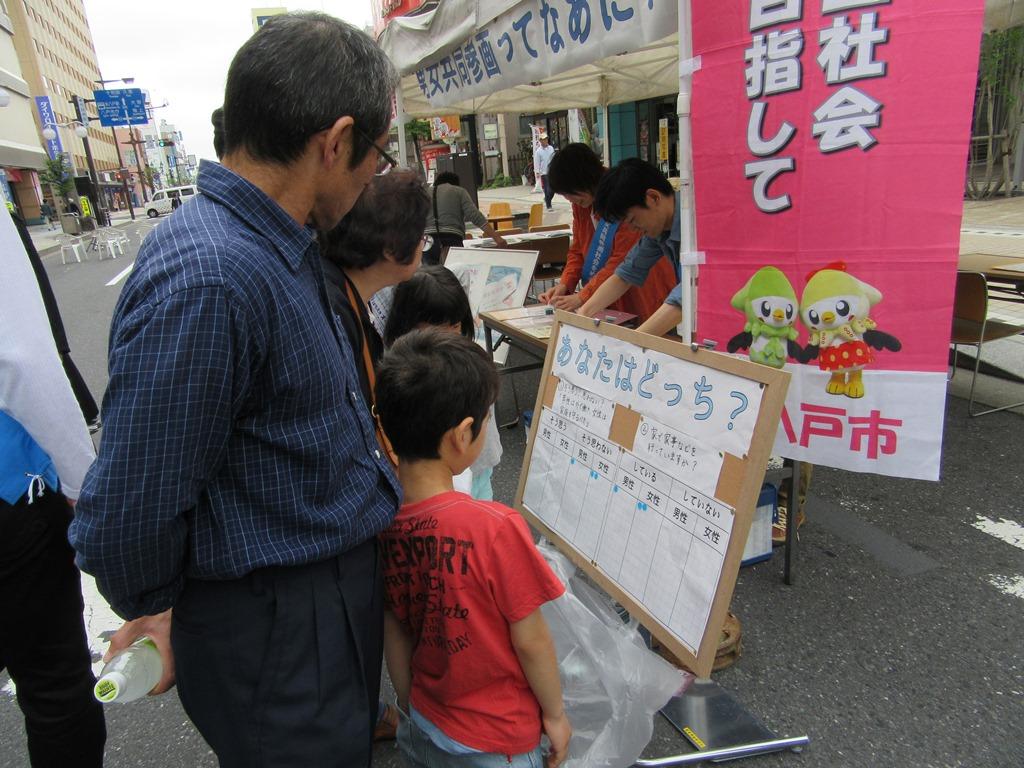 ボードに書いているアンケートを眺める子供2二人と祖父母の写真