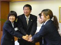 八戸市出身の隊員3名と小林眞市長が握手している写真