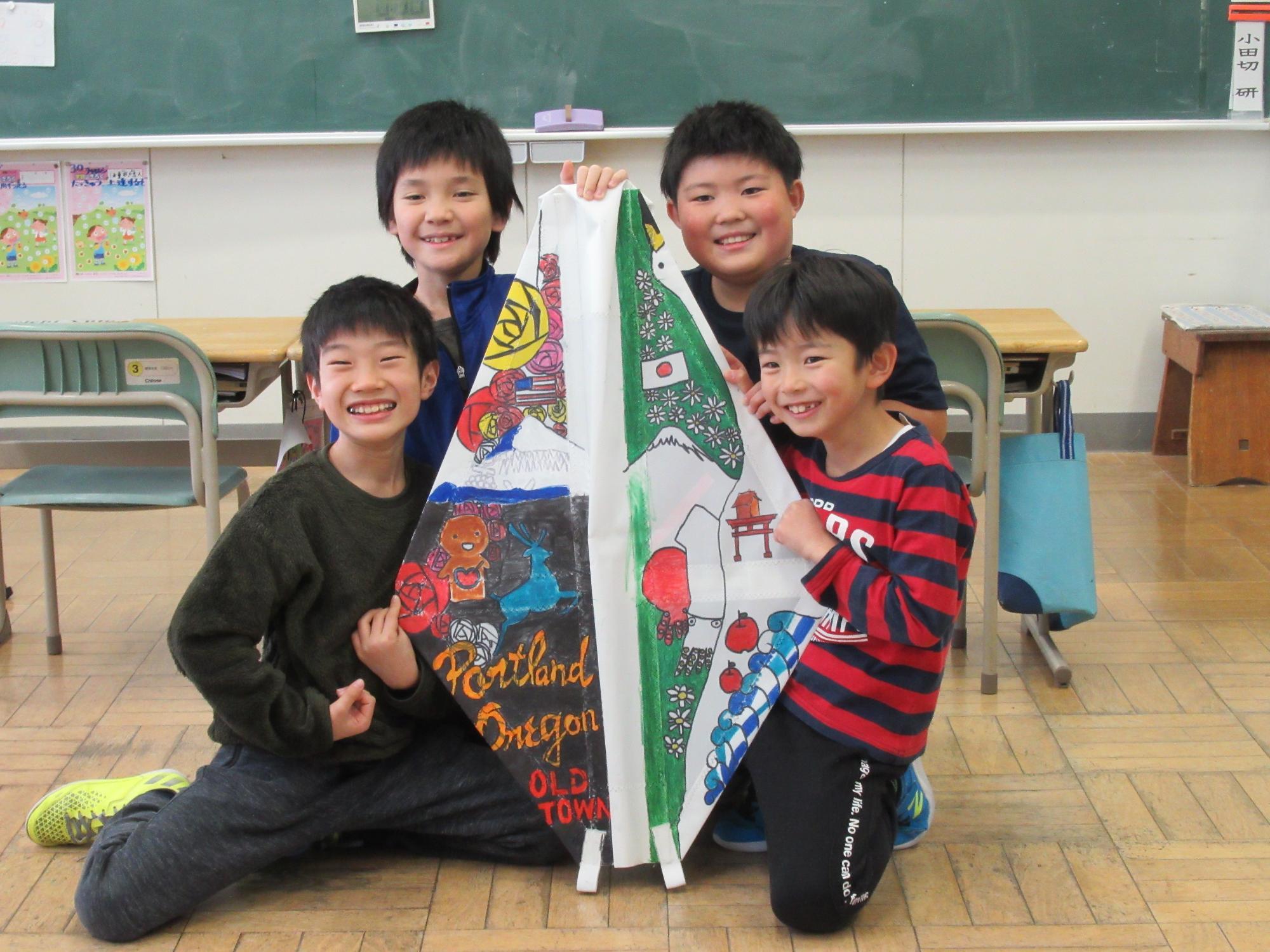 大久喜小学校の生徒が完成した帆を持って笑っている様子
