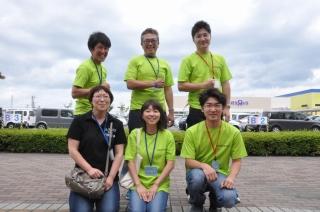 黄緑のTシャツを着て笑顔で写る6人の青年部の記念写真