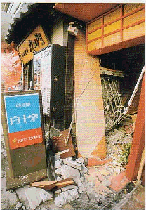 2棟の繋がった飲食店も崩壊し土砂が積まれ看板部分だけが残っている写真