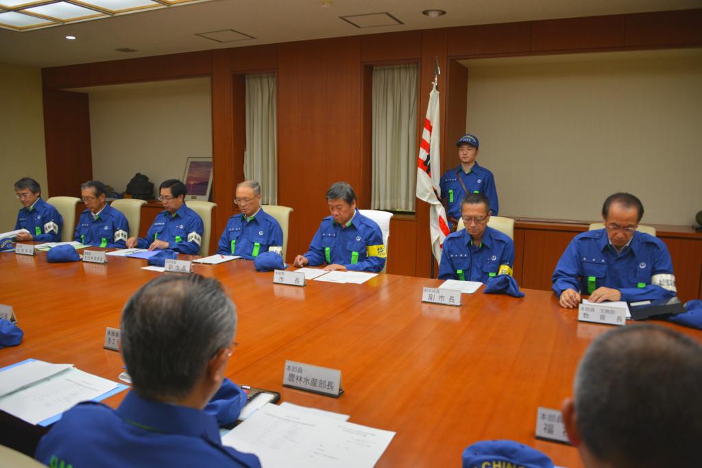青い制服を着用した方々が会議をしている写真