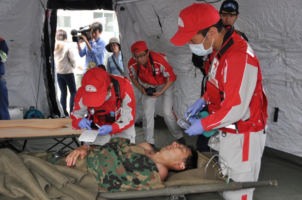 簡易別途に人を寝かせバイタル確認等の救護訓練をしている写真
