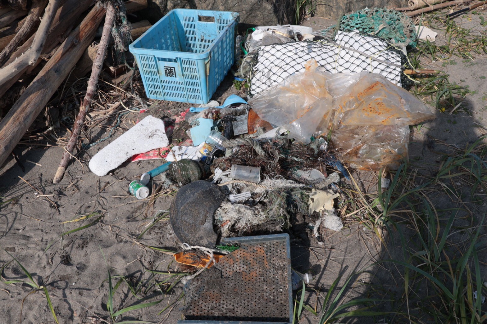 砂浜に集められたプラスチック製の籠などのごみ