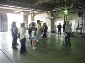 受入室が下はコンクリートで広い空間になっており、見学者が集まって話を聞いている様子の写真