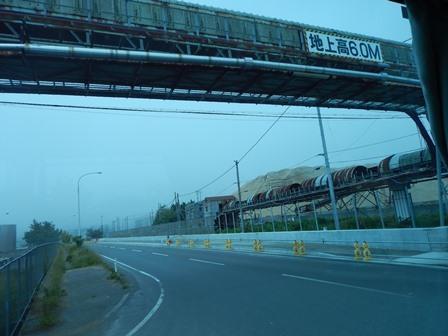 木材チップを運搬する為に、地上高い6.0メートの高さにある橋のようなものが道路の上を渡してある様子の写真