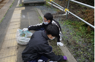大久喜駅周辺の雑草を取りボランティア袋に入れる生徒の写真