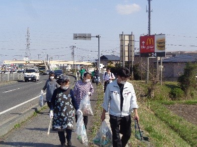 トングを手に道路わきのごみを集めながら歩く5人くらいの写真
