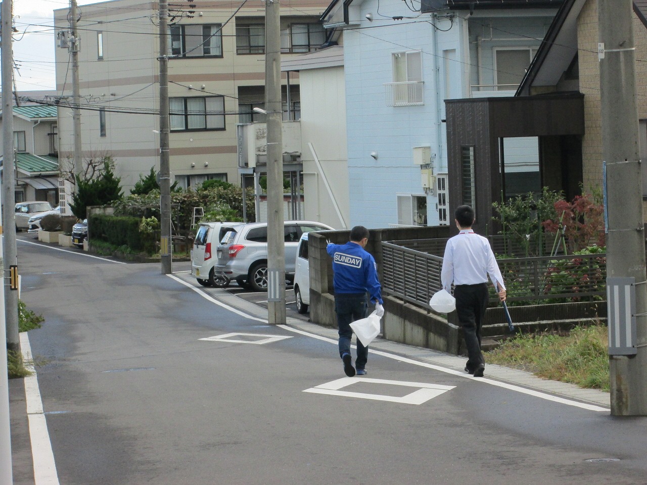 住宅地のごみがないかトングを持ち歩いている2名の写真