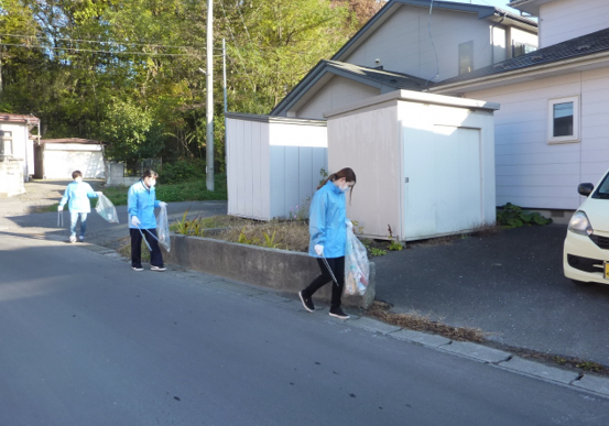 住宅地の道路脇のごみを拾っている写真