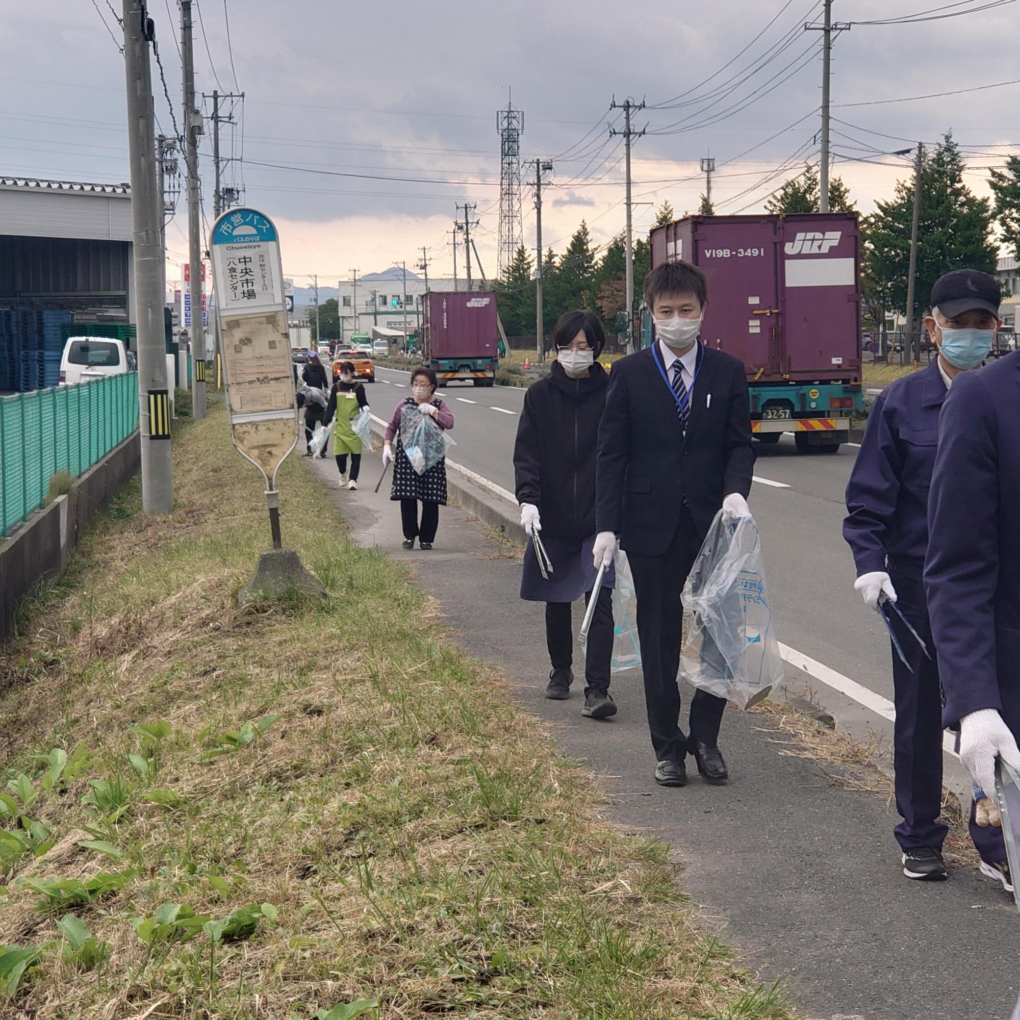 中央市場バス停の周りのごみを拾っている写真