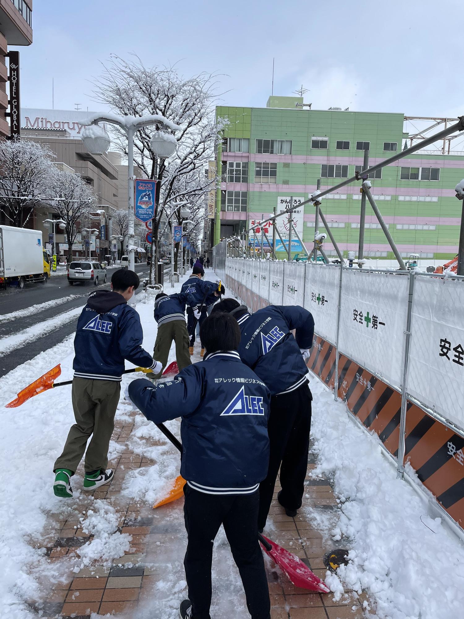 中心街歩道にて除雪を行う5人の生徒さんたち