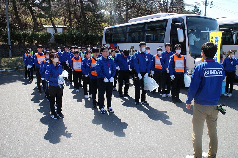 蕪島駐車場のバスの横で開始前に整列している写真