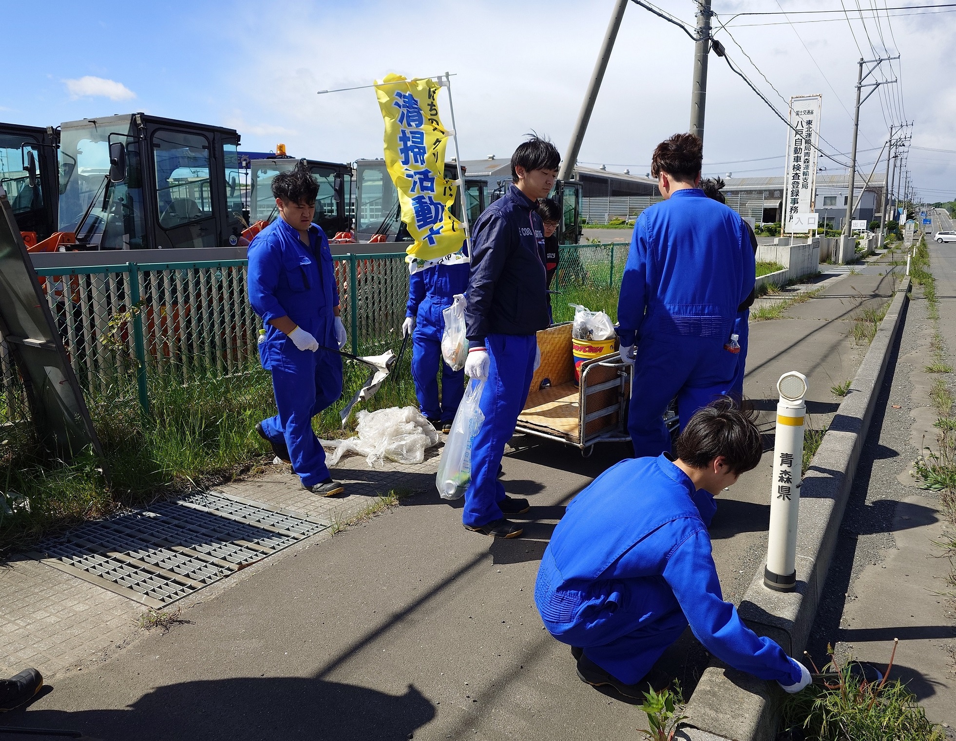 清掃活動の幟を掲げて歩道のごみを拾っている写真